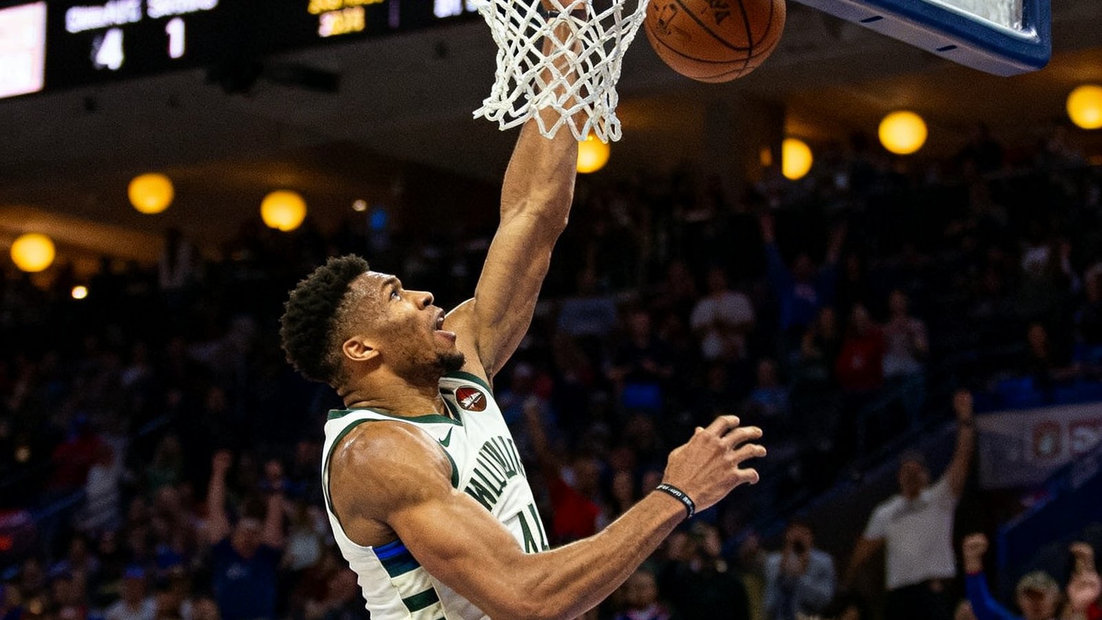 密尔沃基雄鹿队与费城76人队的NBA直播画面,字母哥在内线强力扣篮